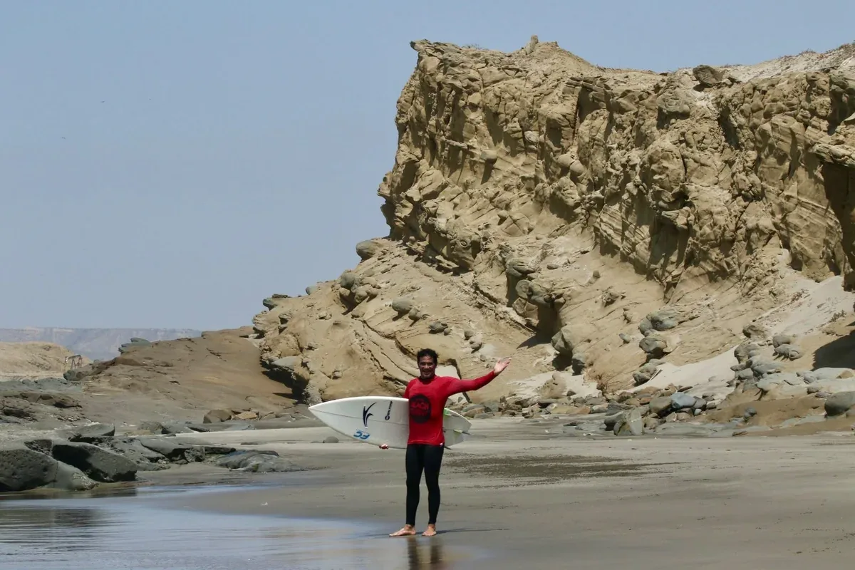 Surfista em frente às falésias do litoral norte peruano