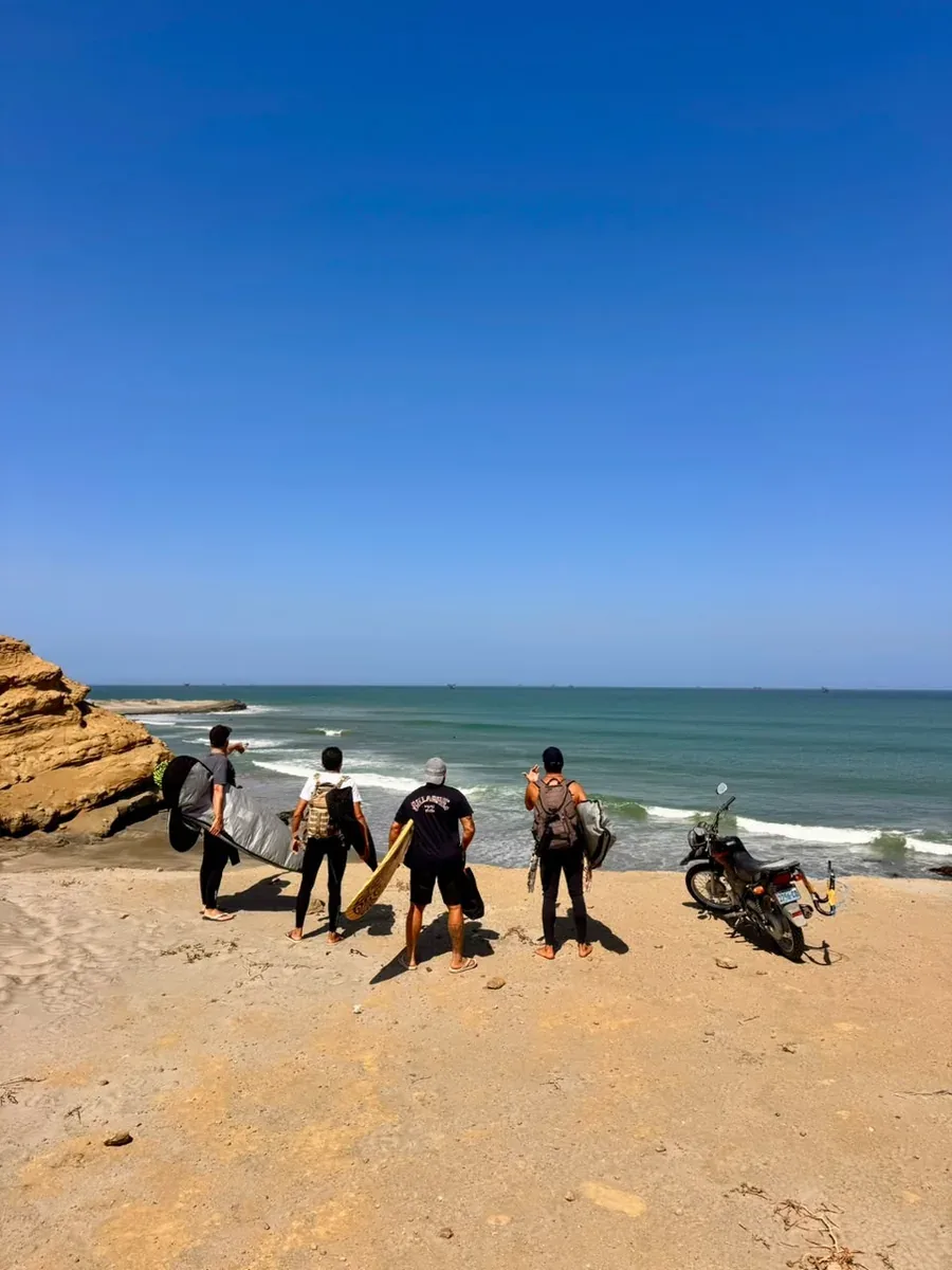 Grupo chegando na praia com as pranchas em Lobitos